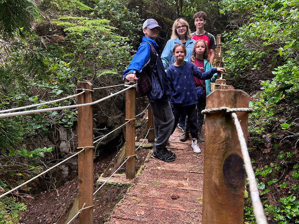 family stop for a photo on the log bridge on the hike to pebble beach