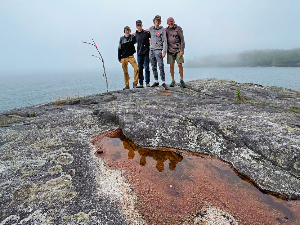 four hikers standing at flat top on malei island